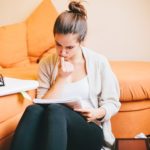 young woman biting nails while studying